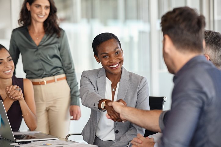 New team member welcomed with a handshake at a meeting